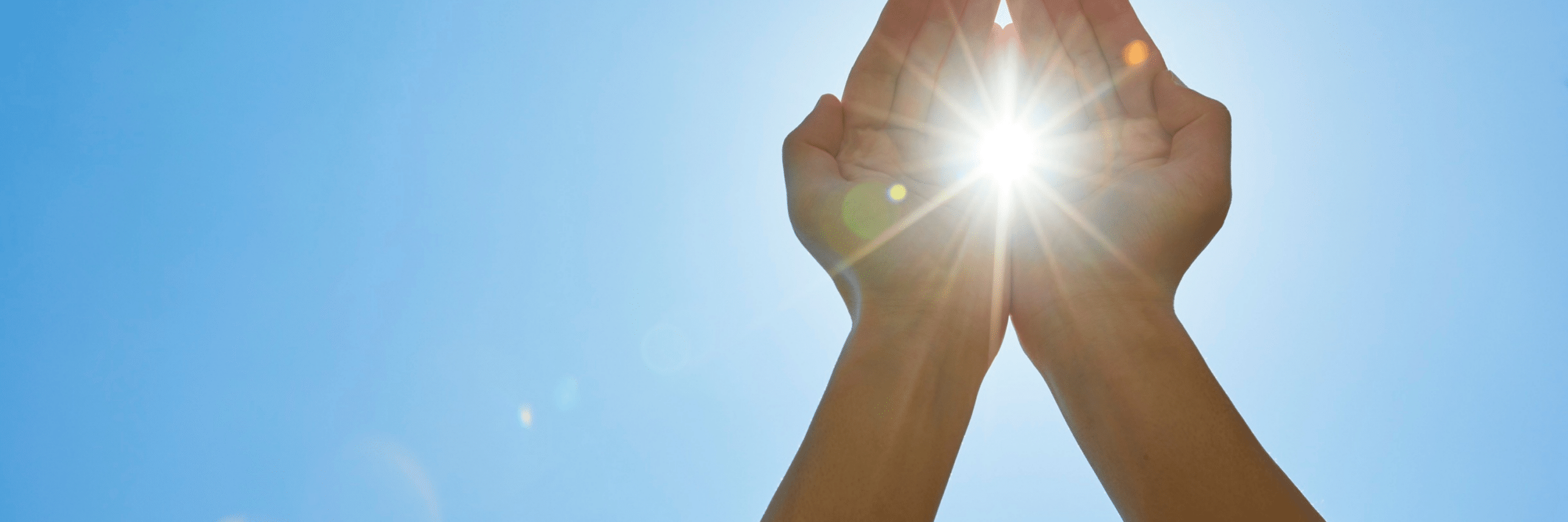 2 handen die de zon vasthouden